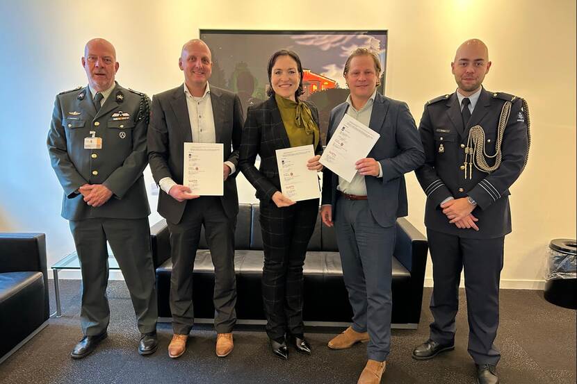 Staatssecretaris Tuinman op de foto met 2 ondertekenaars van de Letter of Intent met Limburg en 2 militairen.