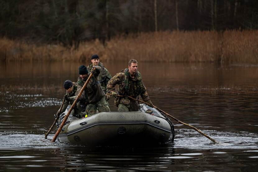Vier Nederlandse militairen in een rubberboot tijdens een oefening in Litouwen