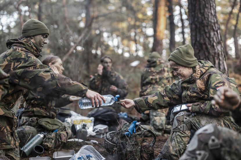 Een deelnemer aan de eindmars schenkt de ander water in. Ze zijn aan het eten.
