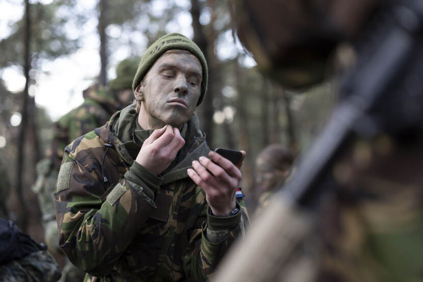Een deelnemer camoufleert zijn gezicht met een groene kleur.