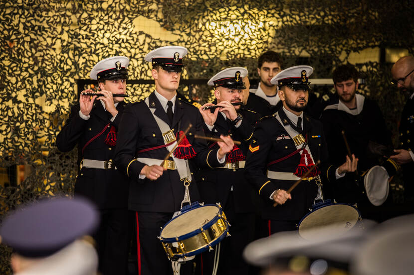 Tamboers en pijpers maken muziek.