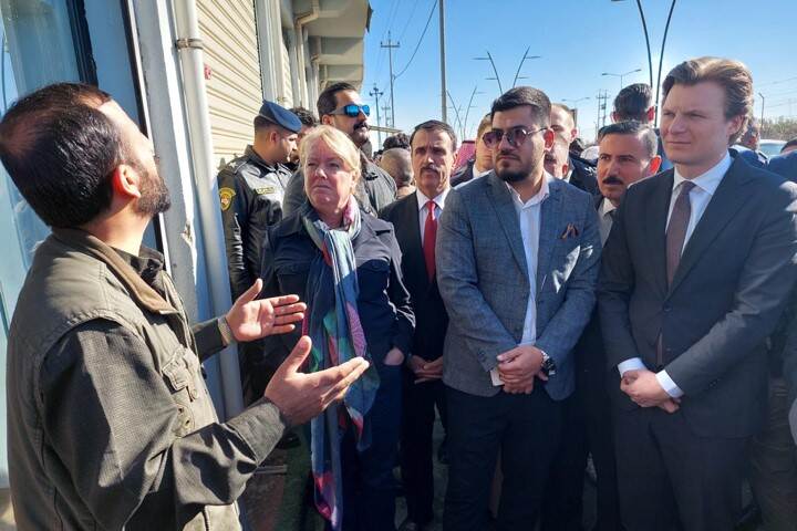 De minister luistert in Irak naar een man.