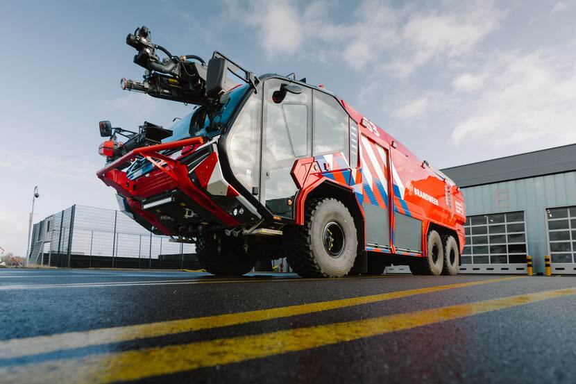 Brandweervoertuig met veel rood, strepen en grote glazen cabine.