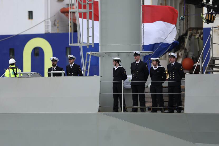 Bemanningsleden op het dek van De Vlissingen. Op de achtergrond de Nederlandse vlag.