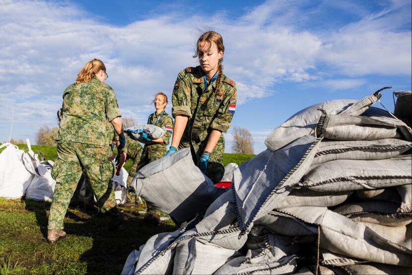 Vrouwelijke militairen slepen met zandzakken.