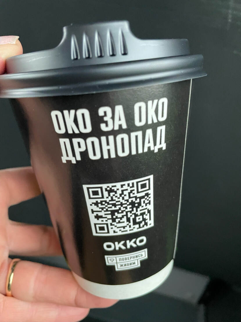 Wegwerp koffiebeker met QR-code en Oekraïense tekst.