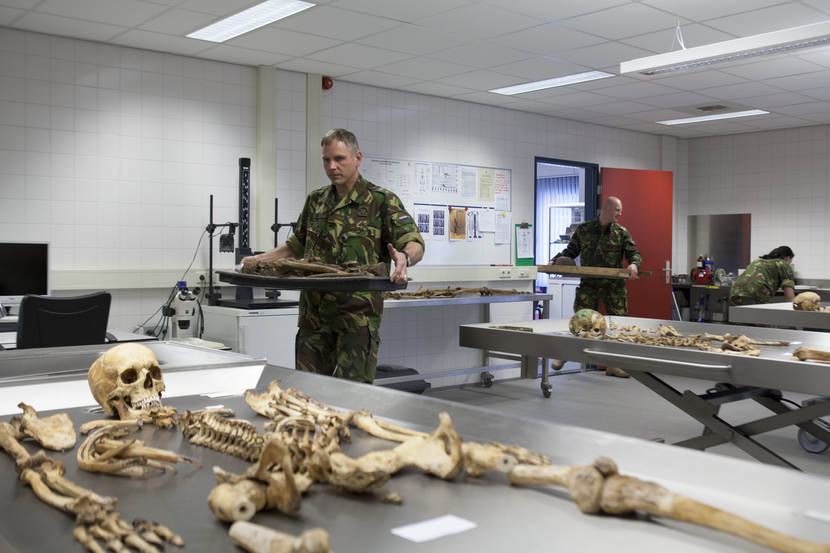 Medewerkers van de BIDKL dragen gevonden resten van onbekende soldaten het laboratorium in.