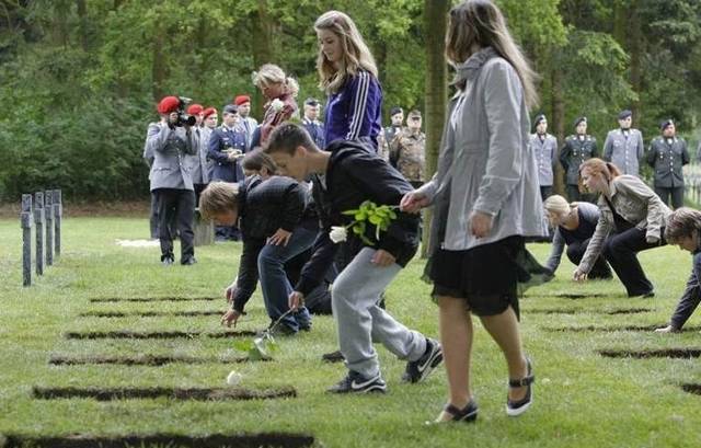 Jongeren leggen rozen op de Begraafplaats voor Duitse Gesneuvelden in Ysselsteyn.