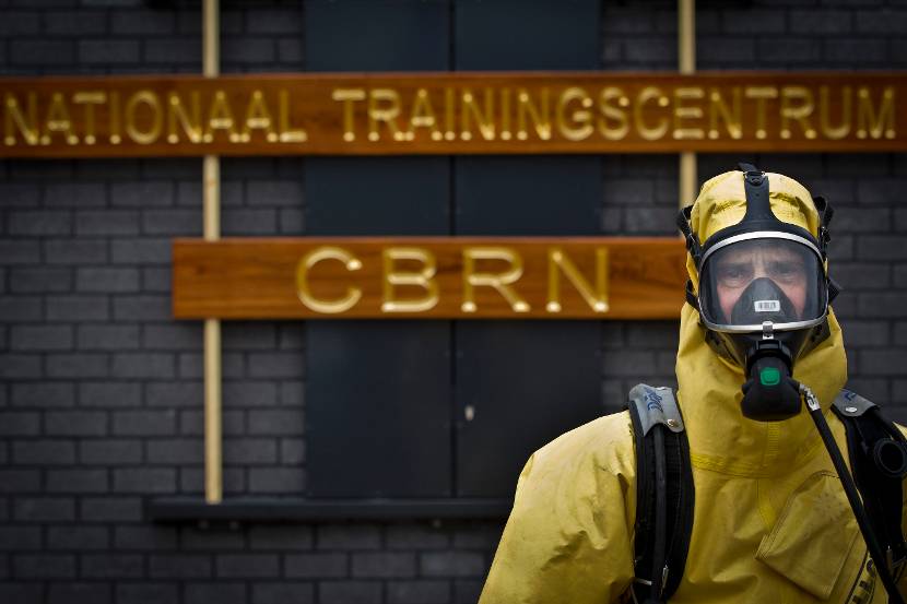 CBRN-specialist met beschermde kleding voor het Nationaal Trainingscentrum CBRN.