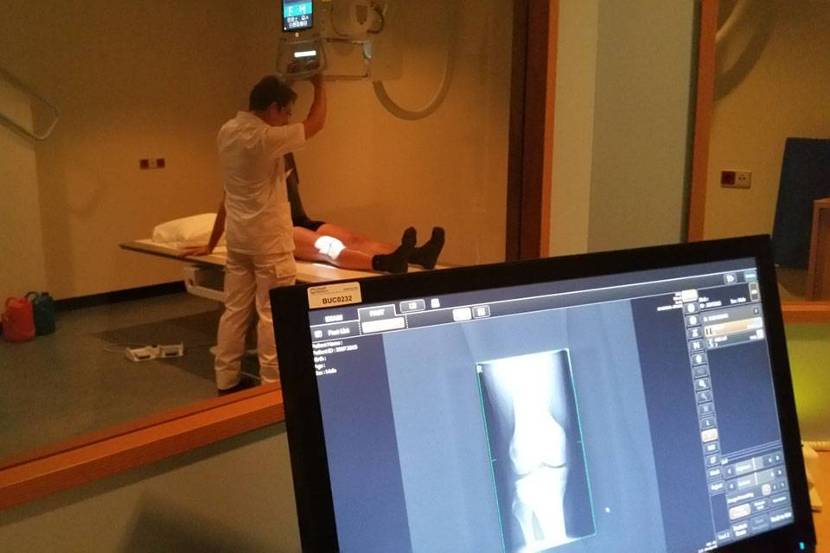 Een laborant van radiologie maakt röntgenfoto van knie.