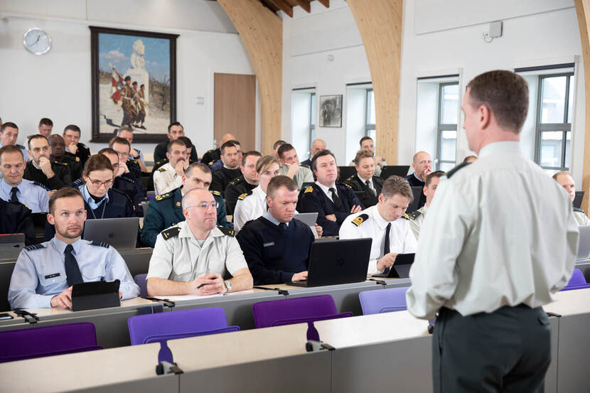 Militaire studenten in collegezaal, met spreker.