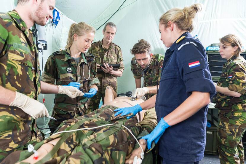 Militairen van de geneeskundige diensten staan rond een lotusslachtoffer.