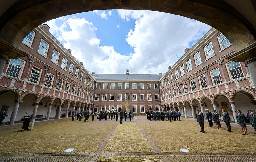 Militairen staan opgesteld op de binnenplaats van een kazerne tijdens een ceremonie.