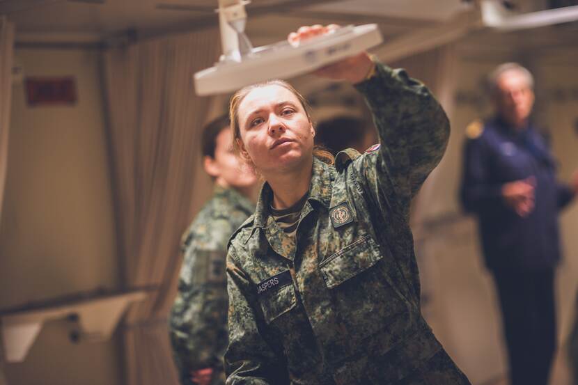Militair bekijkt medische apparatuur aan boord van schip.