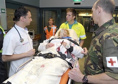 Artsen werken samen met militaire artsen tijdens een crisisoefening.