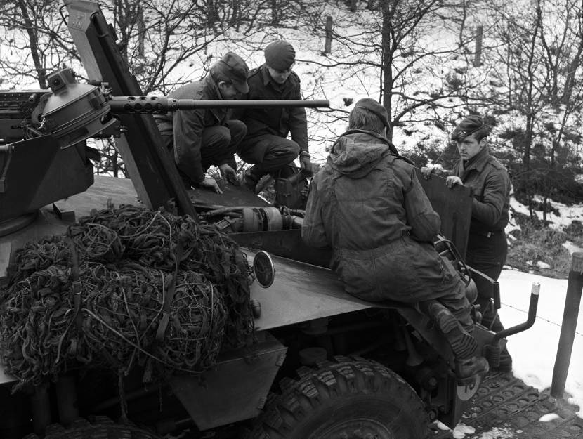 Militairen leunen op een jeep tijdens een oefening. Archieffoto: ministerie van Defensie.