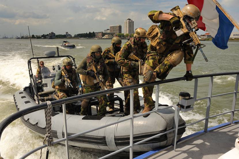 Commando's springen van een rubberbootje op een marineschip.