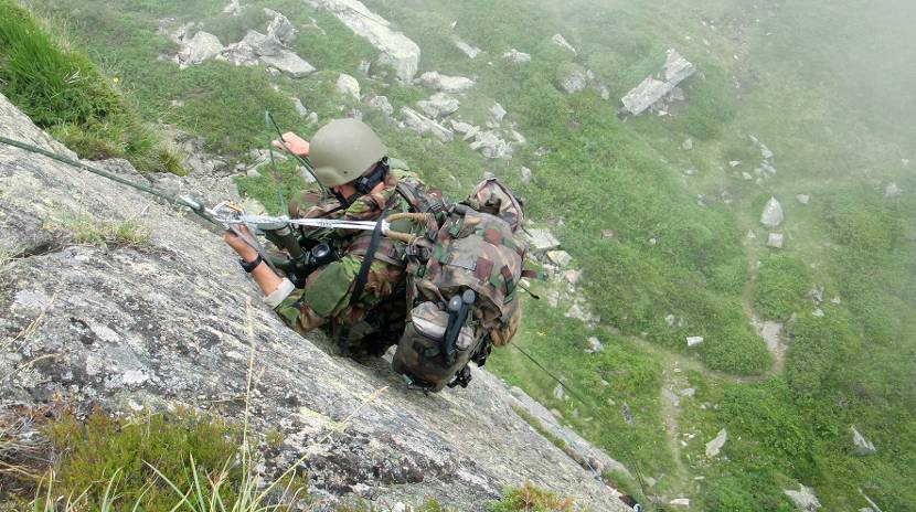 Militair klimt op een berg.