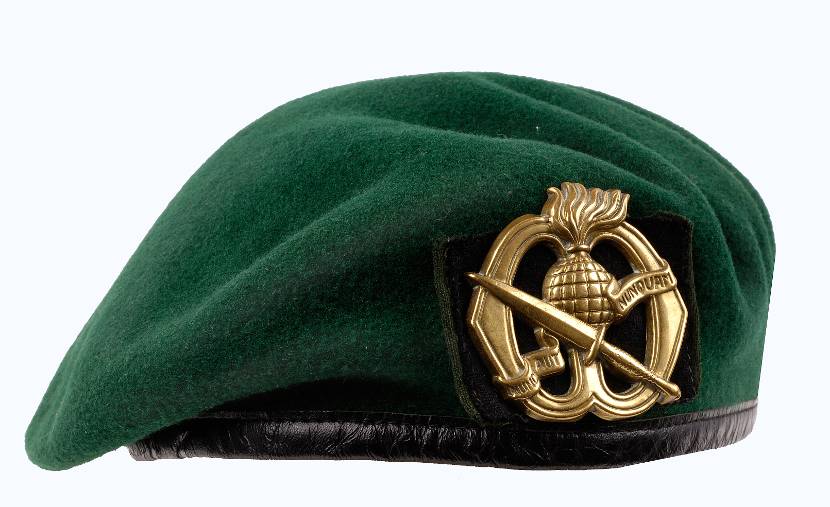 Groene baret met het embleem.