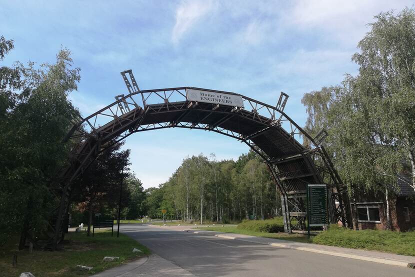 Brug in de vorm van een halve maan over een weg en bord met de tekst 'home of the engineers'.