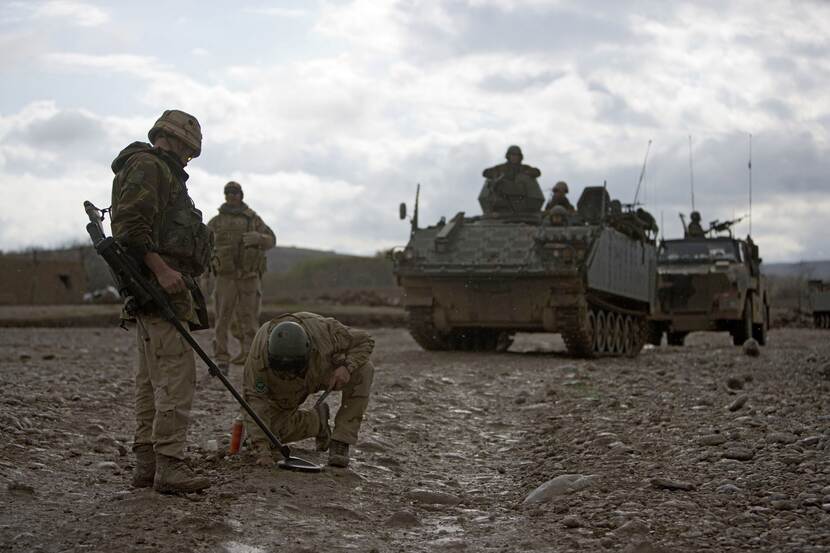 Militairen zoeken bermbommen in Afghanistan, 2008.
