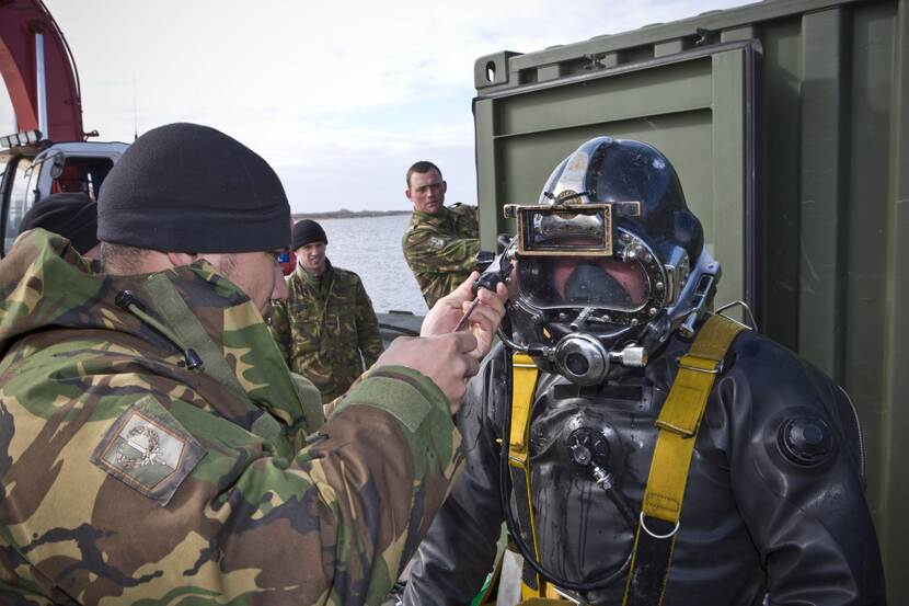 Een duiker wordt door een militair klaargemaakt om te duiken.