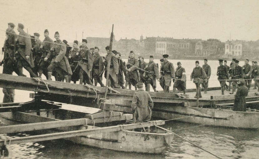 Grote groep militairen lopen over een brug.