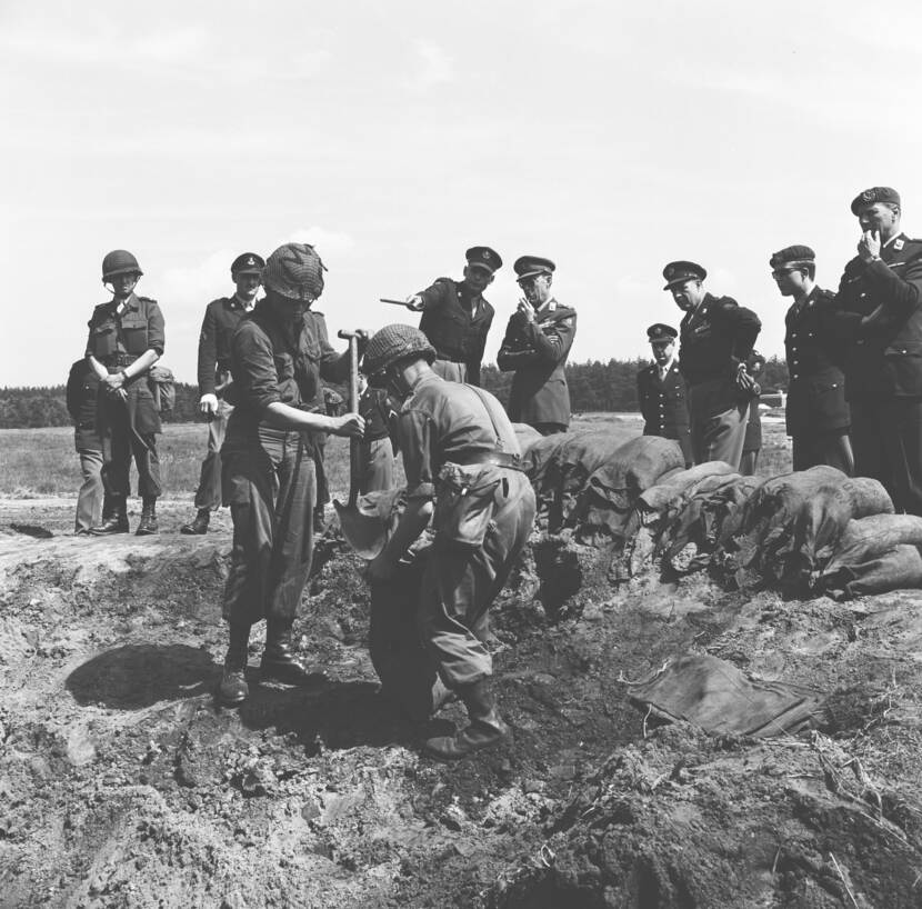 1965. Militairen vullen zakken met zand. Prins Bernhard inspecteert de genisten.