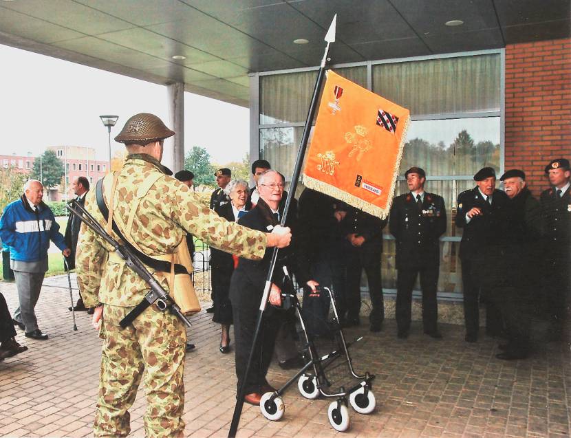 Militair draagt het vaandel van het Regiment Infanterie Johan Willem Friso.