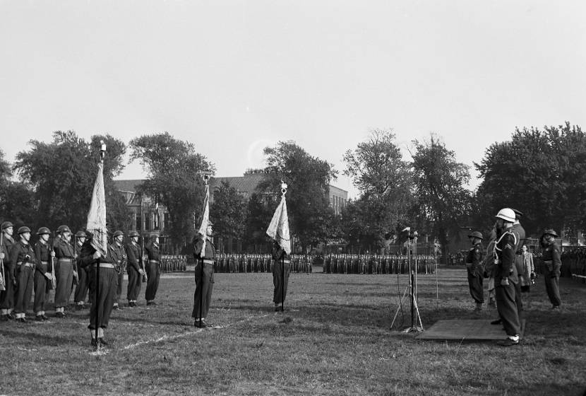 Militairen staan met vaandel opgesteld.