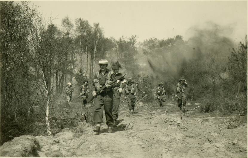 Militairen lopen over een veld.