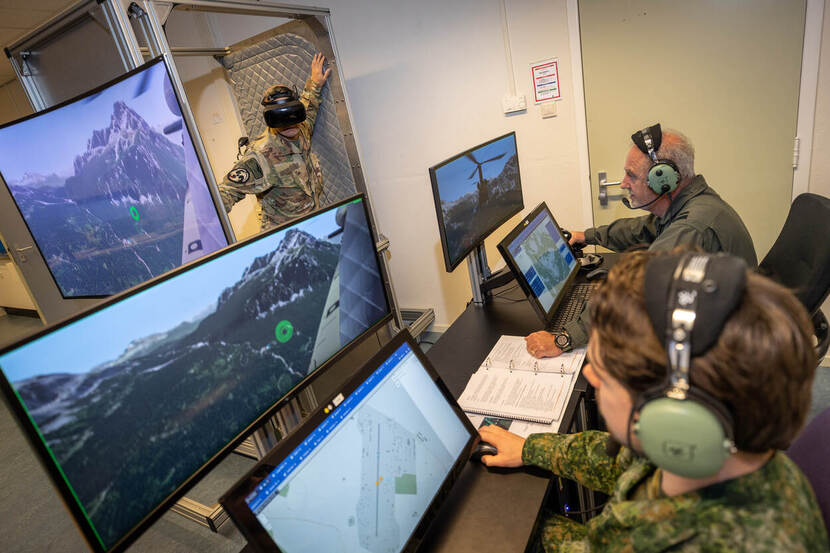 Militairen kijken naar computerschermen en 1 militair heeft een virtual reality bril op.
