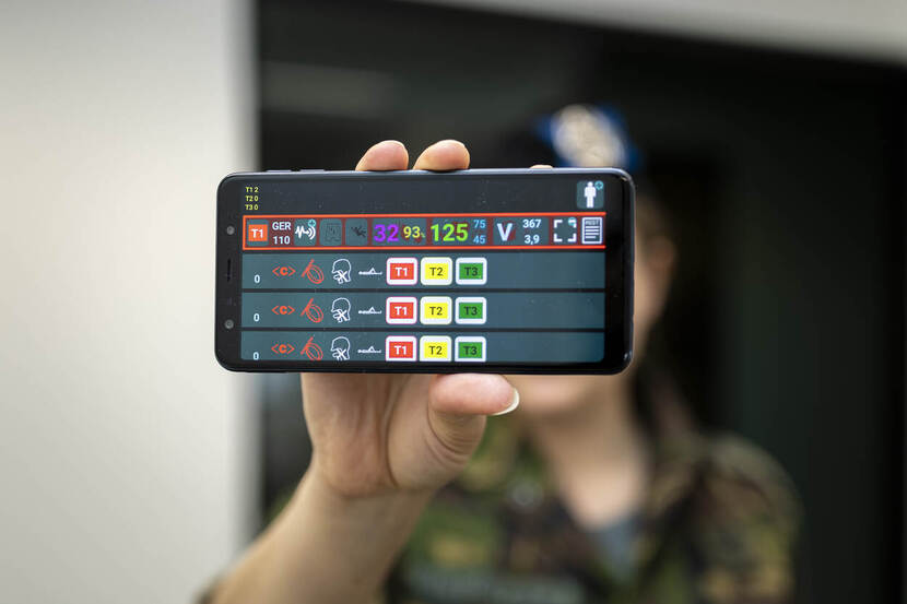 Militair toont telefoon met app.