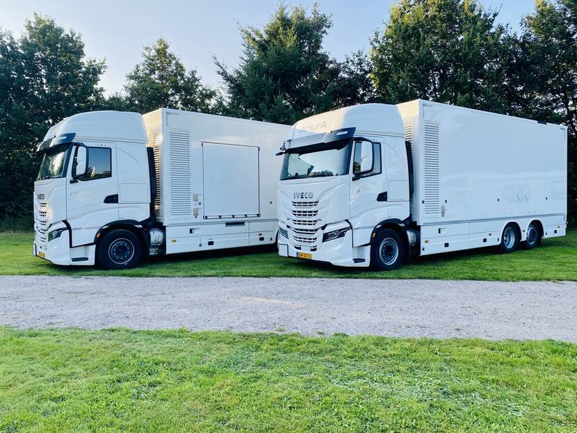 2 duiktrucks naast elkaar geparkeerd op een grasveld.