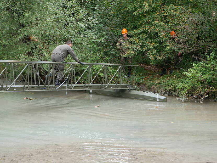 Militairen steken de Mamba-infanteriebrug over. De infanteriebrug is opgezet over water.