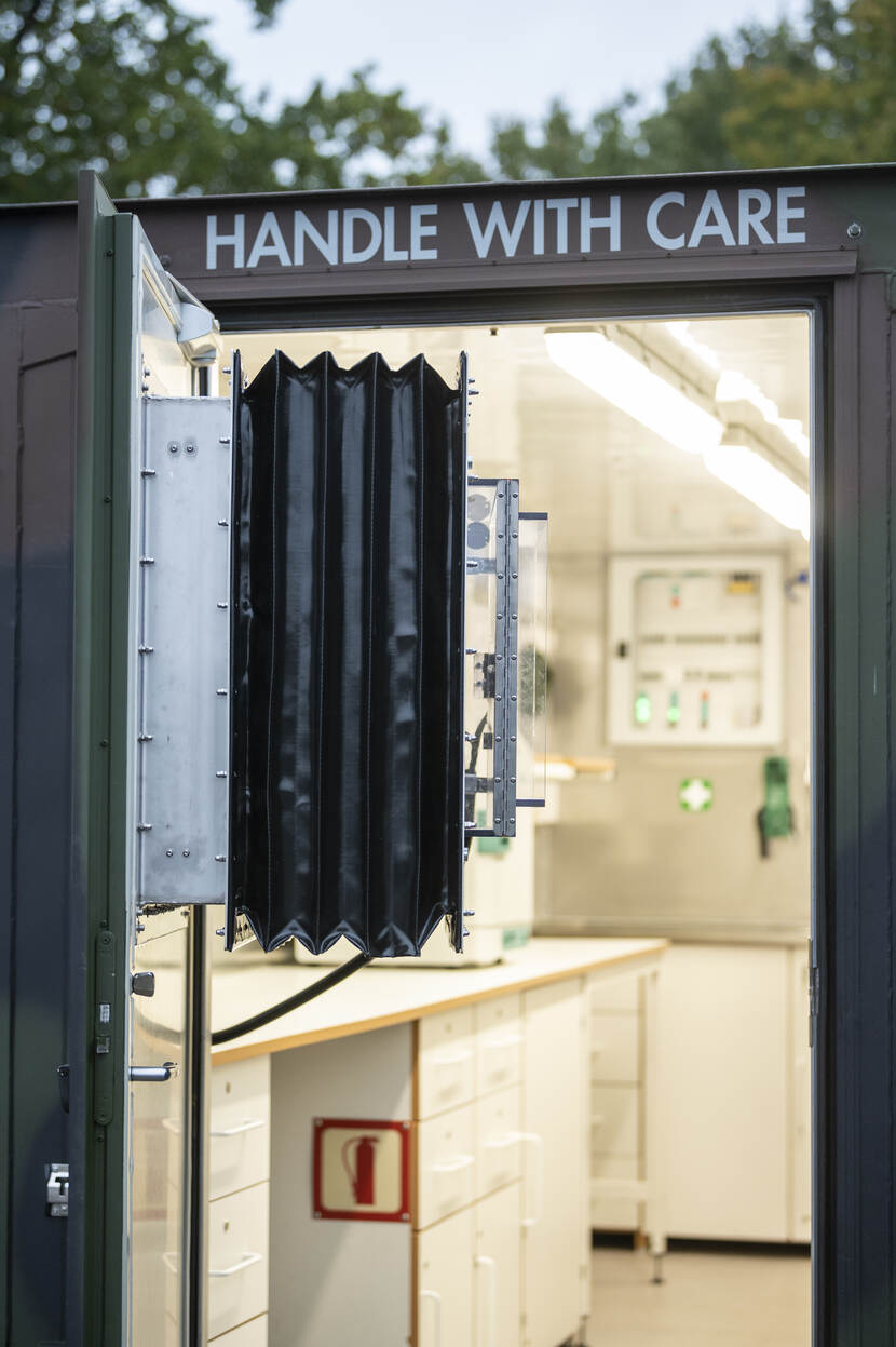 Het laboratorium van de Mobiel geneeskundige containers met openstaande deur met doorgeefluik.