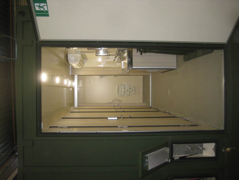 Mobiele geneeskundige sanitaircontainer met toiletten. De deur van de container staat open.