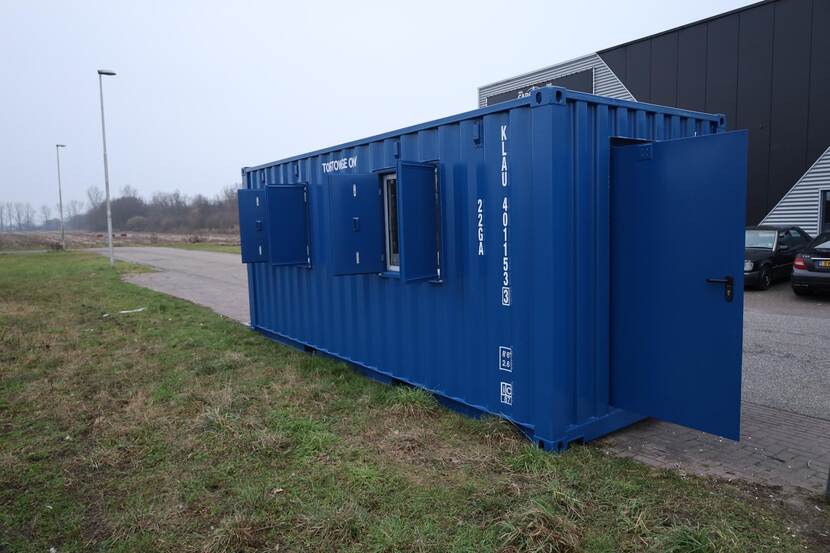 Blauwe container met open deuren en ramen voor een magazijn.