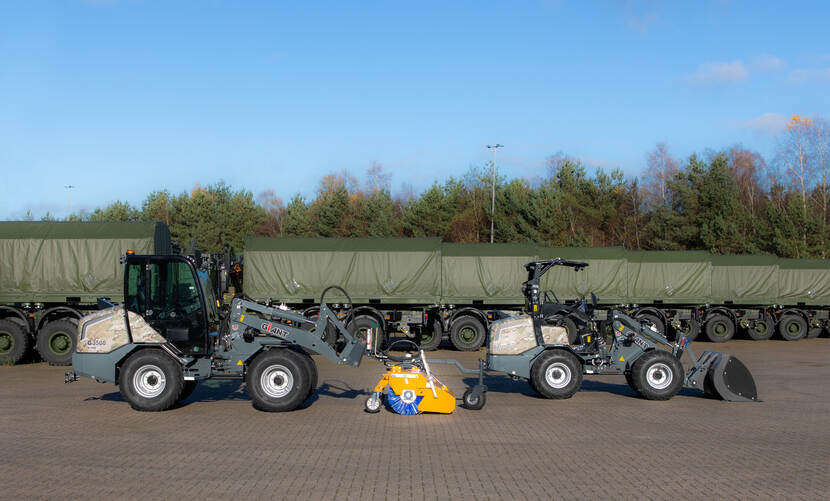 2 wiellaadschoppen op een parkeerplaats met aanhangwagens met een opzetborstel tussen de voertuigen in.