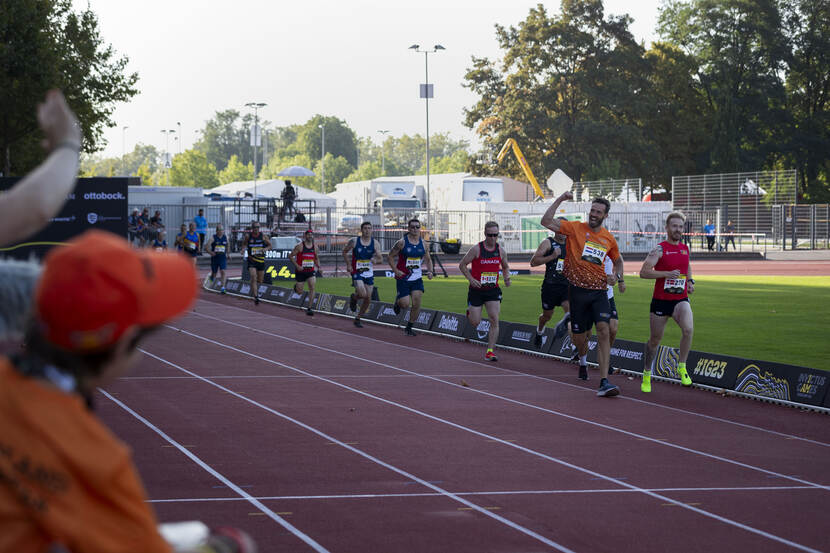 Heren rennend achter elkaar op de atletiekbaan.