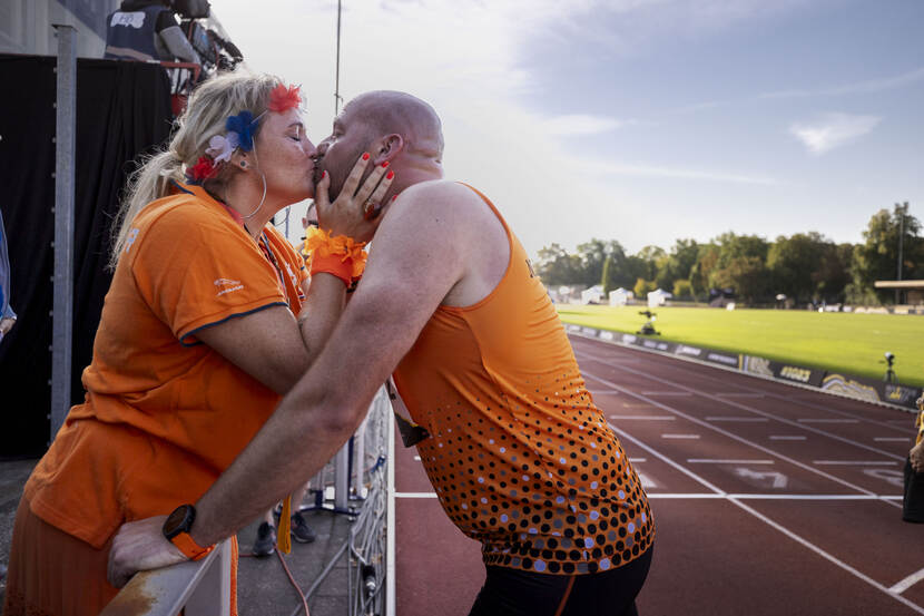 Een sporter wordt door zijn vrouw gekust.