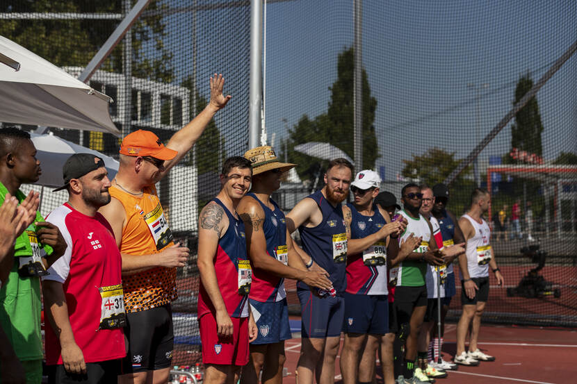 Sporters van verschillende nationaliteiten staan naast elkaar.