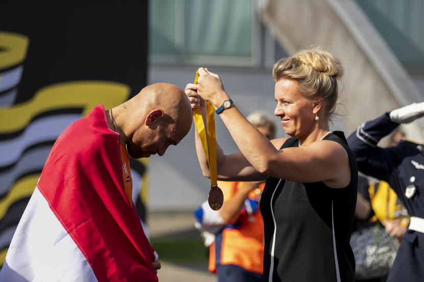 Sporter krijgt medaille om zijn nek.