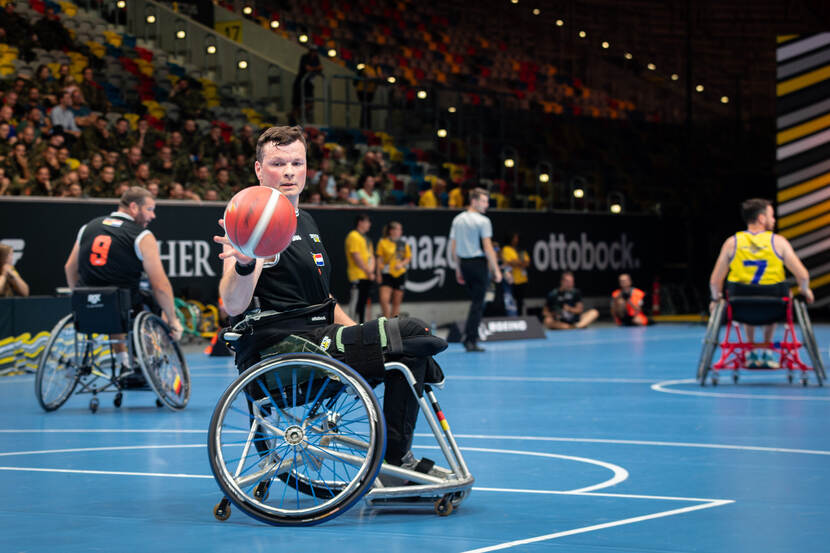 Een deelnemer aan rolstoelbasketbal heeft de bal.