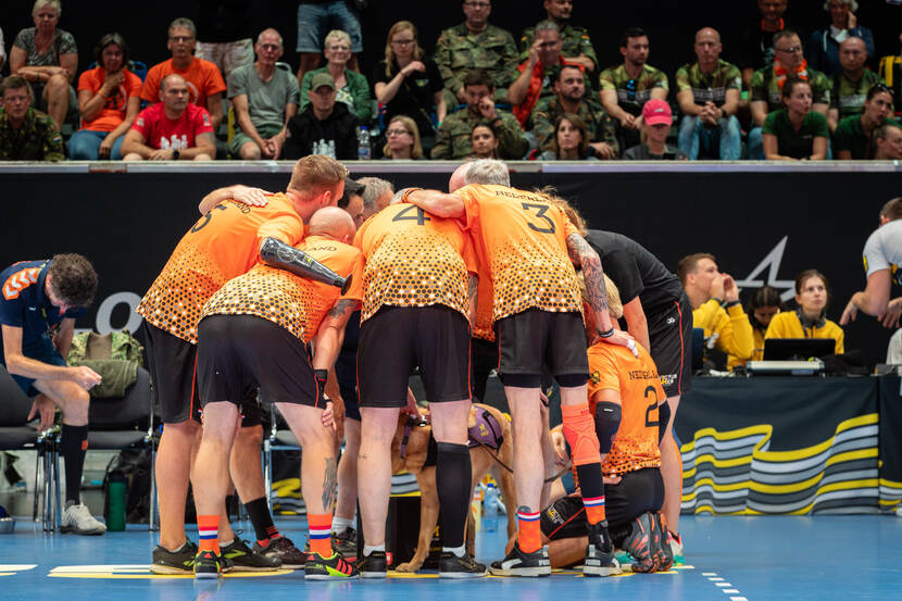 Nederlandse volleyballers overleggen in een kring.