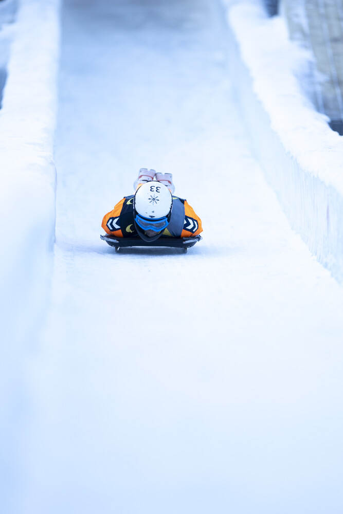 Een persoon glijdt op het ijs tijdens de skeleton-wedstrijd.