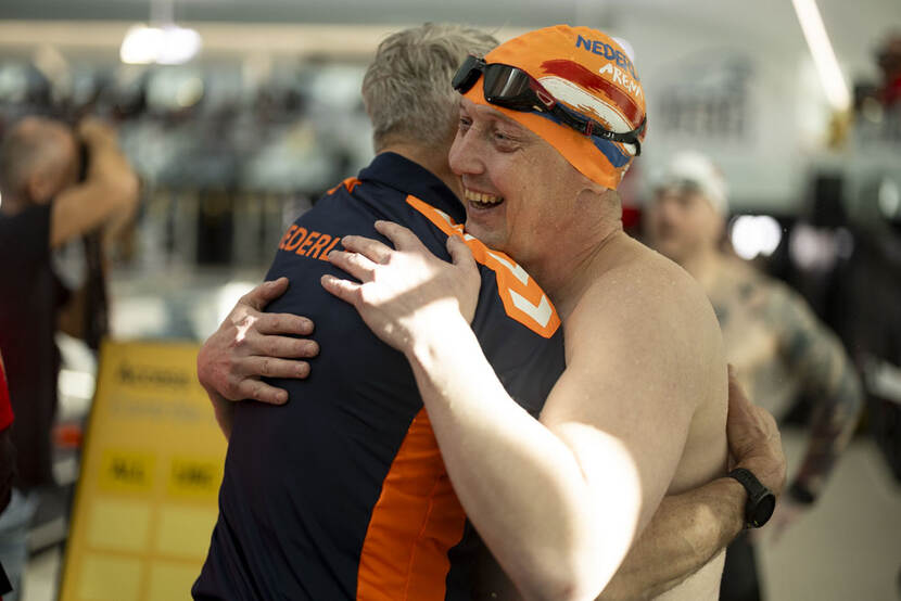 2 sporters omhelzen elkaar.