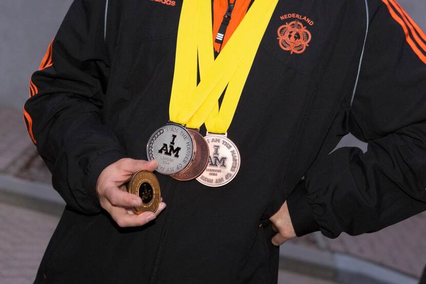 Een Nederlandse sporter houdt de gewonnen medailles tijdens de Invictus Games in 2014.