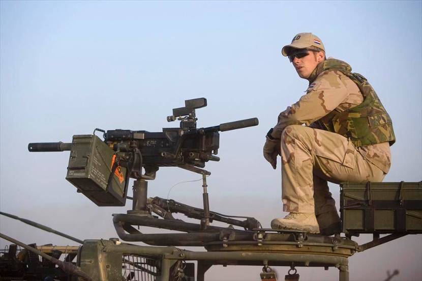 Militair zit achter een automatische granaatwerper die op een voertuig affuit staat.