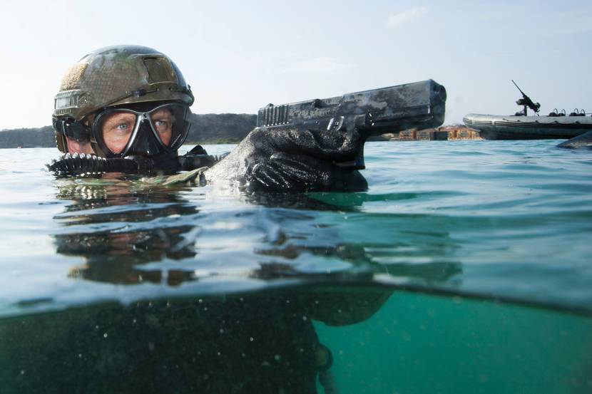 Een duiker van het Korps Commandotroepen met een Glock 17 Gen4 die net boven het water uitsteekt.